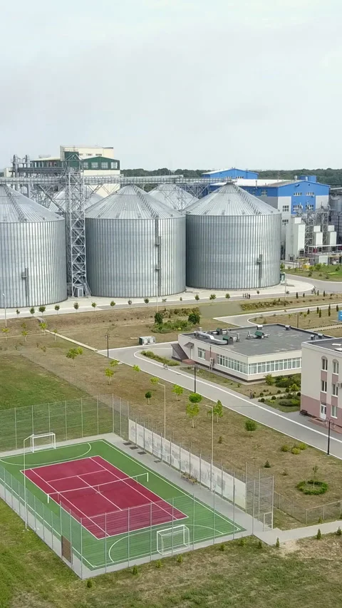 Aerial view of grain elevators surrounded by green fields.  Stock Footage 296734647