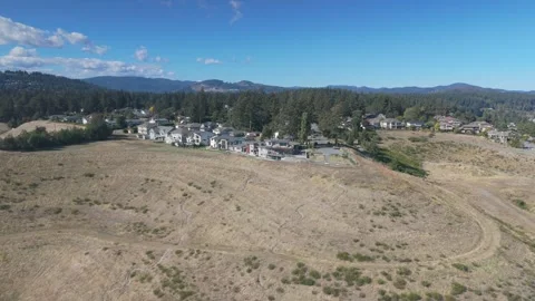 Aerial view of a grassy hillside with a cluster of houses at the top Stock Footage 285999835
