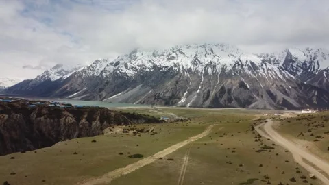 Aerial view of grassy meadows and snowy mountain peaks near Ranwu Lake Video stock 342245607
