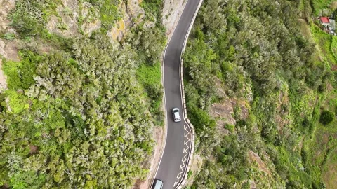 Aerial view of a gray car navigating a winding mountain road Stock-Footage 328054932
