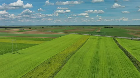 Aerial view of green agricultural fields and highway with trucks Stock Footage 345447076