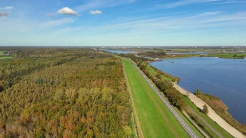 Aerial view of a green dike separating a forest from a river Video stock 320813181
