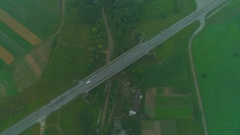 Aerial view. Green fields and village enclosed by road. 4K. Stock Footage 110006276