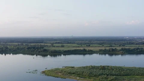 Aerial view green fields and forests on river shore. Parasail flying over river Stockbeeldmateriaal 116187372