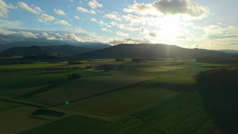 Aerial view of green fields and Alpine mountains near Ohlsdorf at sunset Stock Footage 330875637