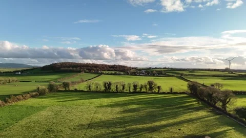 Aerial View of Green Fields and Wind Turbine Under Dramatic Clouds 스톡 동영상 332738756