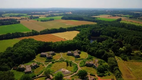 Aerial view of green fields and abandoned buildings near wooded area Stock Footage 339782574