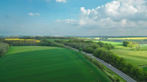 Aerial view of green fields and a road under blue sky Stockbeeldmateriaal 346852691