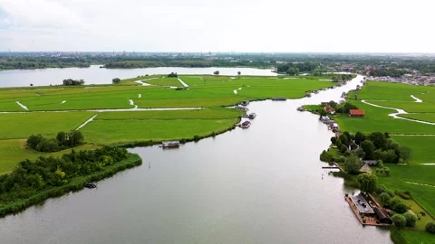 Aerial view of green fields divided by winding canals, riverside houses Vídeos de archivo 316551653