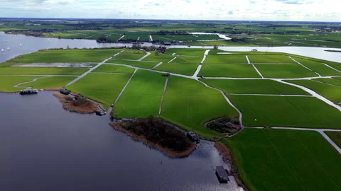 Aerial view of green fields divided by narrow water channels with waterfront Stock Footage 336928895