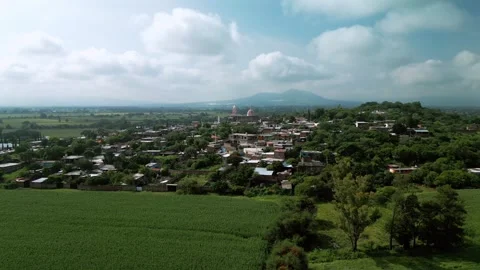 Aerial view of green fields with a town on the horizon Stock Footage 342061970