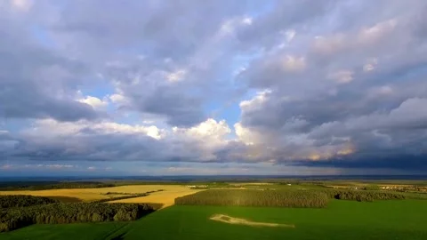 Aerial view of green fields under a dramatic sky Stock Footage 333829230