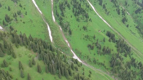 Aerial view of green mountain slopes with snow Stock Footage 345388151