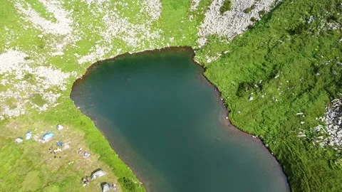 Aerial view of green mountains with lake in the mountains with blue water Stock Footage