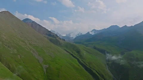 Aerial view of green mountains with white clouds at evening summer in Kyrgyzstan Vidéo 312428862