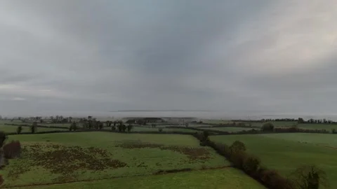 Aerial View of Green Patchwork Farmland Under Overcast Sky Stock Footage 332569092