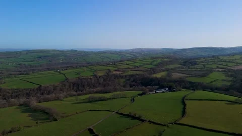 Aerial view of green patchwork farmland and rolling hills Stock Footage 332620659