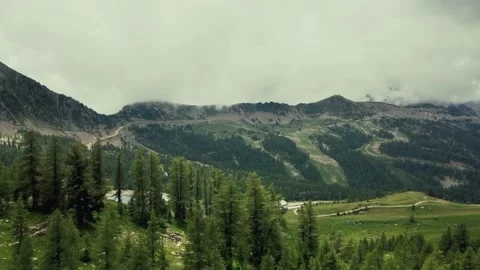 Aerial view of green pine forest and mountain range under cloudy sky Vídeos de archivo 328301079