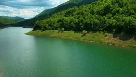 Aerial view of a green river winding through forested hills. Zavoj Lake, Serbia Video stock 337488455