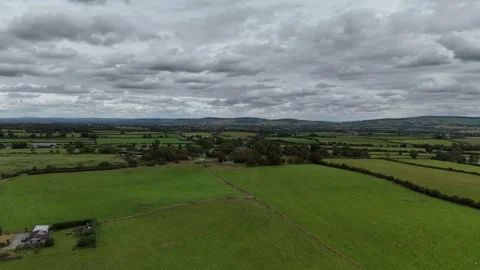 Aerial View of Green Rural Fields Under Cloudy Sky Stockbeeldmateriaal 333412906