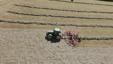 Aerial view of a green tractor pulling a grass collector across a freshly Stock Footage 281766506