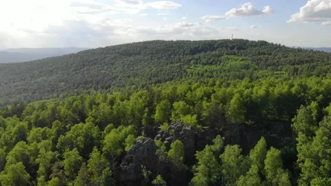 Aerial view of green trees at the top of the mountain. The sun illuminates the Stockbeeldmateriaal 156642741