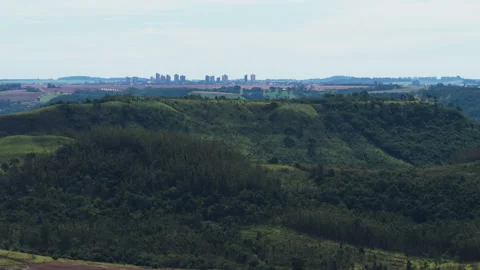 Aerial View of Green Valley With Distant City Skyline Stock-Footage 336336759