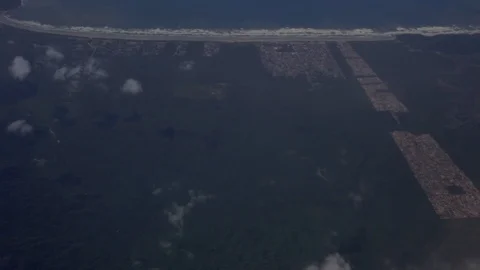 Aerial view of grid pattern square building complex set in forest by beach in 스톡 동영상 101302187