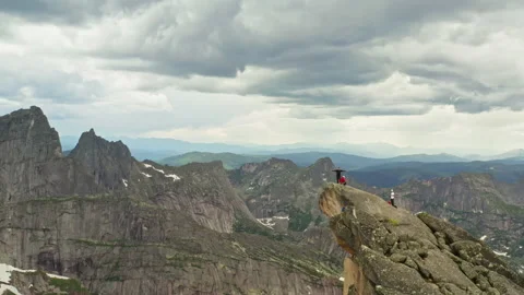 Aerial view of a group of hackers standing on a rocky peak. Tourists in the Stock Footage 163258481