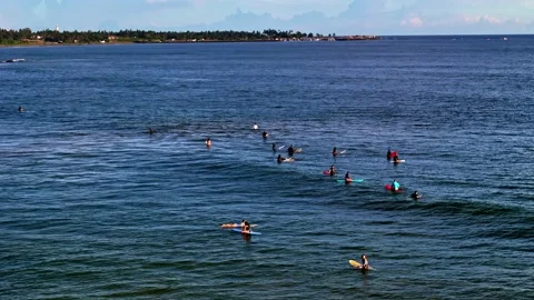 Aerial view of a group of surfers paddling and waiting on their boards in calm 動画素材 331663172