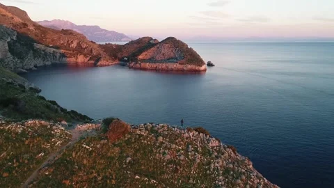 Aerial View Of a Guy Standing On The Cliff During Sunset In Italy Video stock 139875703