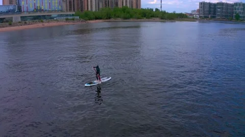 Aerial view of a guy standing on a sub, floating on a river Video stock 136215689