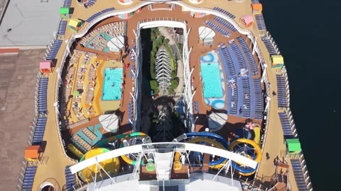 Aerial View Of Harmony Of The Seas With Pools, Slides, And Tourists On Deck Video stock 318624582