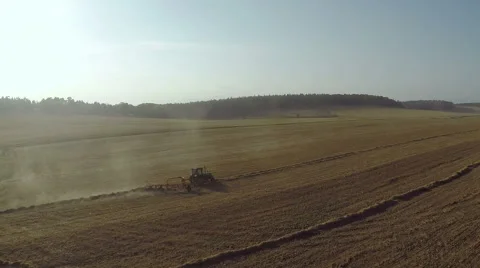 Aerial view of hay rake pulling by tractor at mooring sun Stock Footage 52669598