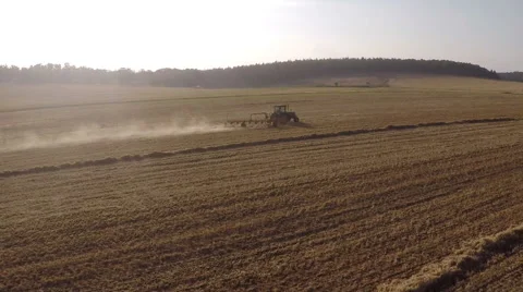 Aerial view of hay rake pulling by tractor at mooring sun Stock Footage 52671025