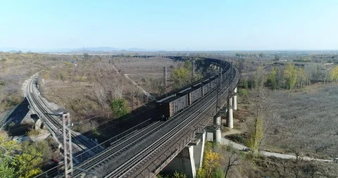 Aerial View of Heavy Loaded Cargo Train Runs on Railway Bridge Stock Footage 119489409