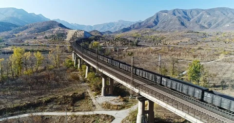 Aerial View of Heavy Loaded Cargo Train Runs on Railway Bridge Stock Footage 119489700