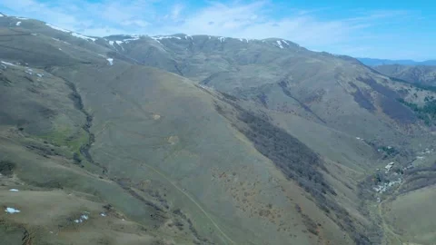 Aerial view of high mountains covered with snow against a blue sky Drone footage Stock Footage 257428041