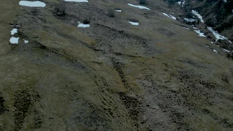 Aerial view of high mountains covered with snow against a blue sky Drone footage Stock Footage 257440022