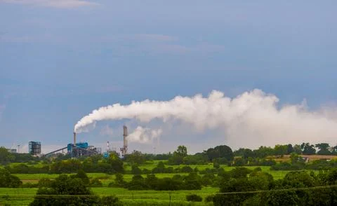 Aerial view of high smoke stack with smoke emission. Plant pipes pollute at.. Stock Photos