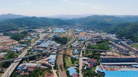 Aerial view of high speed rail tracks and highway infrastructure in mountainous Stock-Footage 347064591