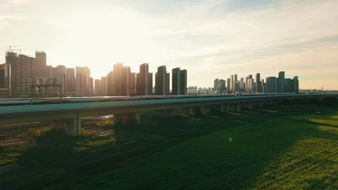 Aerial view of a high speed train travels on an elevated track past tall Stock Footage 340939860