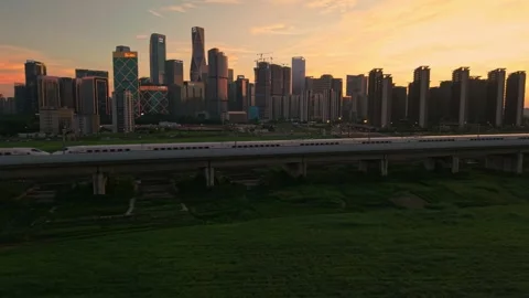 Aerial view of a high speed train travels on an elevated track past tall Stock Footage 341642626