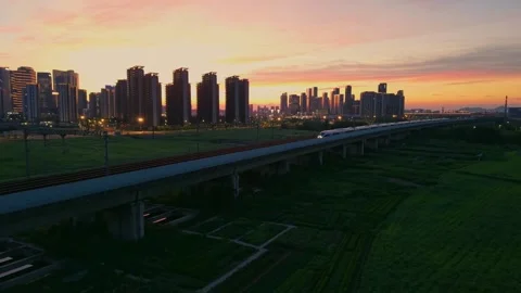 Aerial view of a high speed train travels on an elevated track past tall Stock Footage 341642832