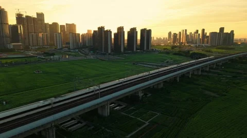 Aerial view of a high speed train travels on an elevated track past tall Stock-Footage 341836944