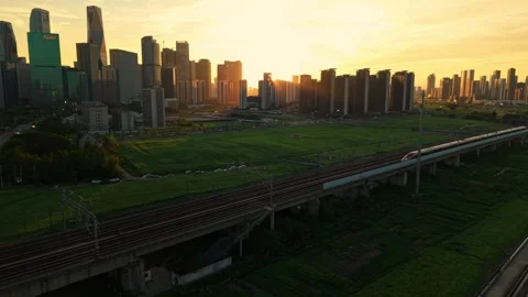 Aerial view of a high speed train travels on an elevated track past tall Stock-Footage 341836945