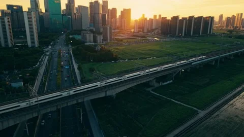 Aerial view of a high speed train travels on an elevated track past tall Stock-Footage 345243728