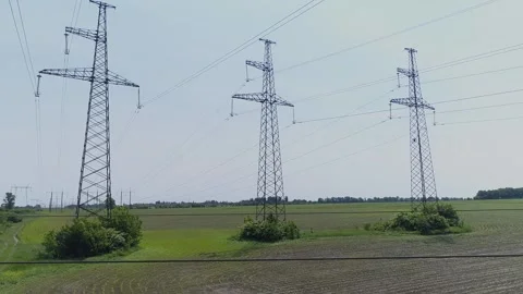Aerial view. High-voltage electrical pylons  in the field Stock Footage 317913374