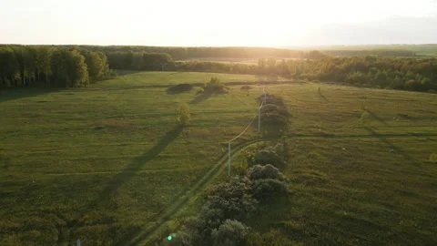Aerial view of high voltage power line electricity pylons in the field in the Stock Footage 254871602