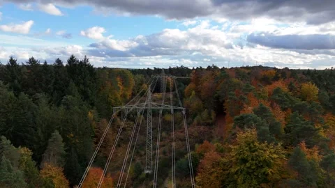 Aerial view of high voltage power lines running through colorful autumn forest Stock Footage 327973492